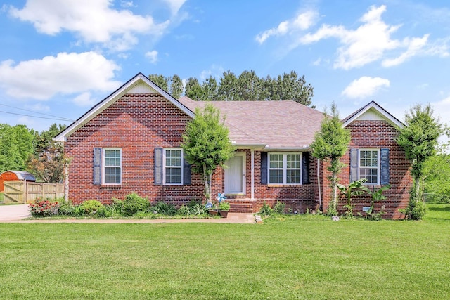 ranch-style house with brick siding, fence, and a front yard