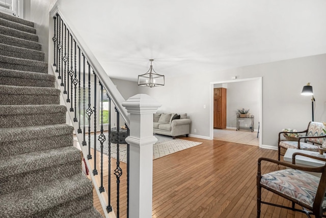 174 Hickory Ln, Jacksboro, TN 37757 - living room featuring baseboards, stairway, a notable chandelier, and wood-type flooring