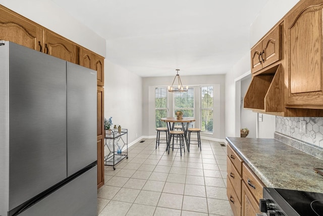 174 Hickory Ln, Jacksboro, TN 37757 - kitchen with brown cabinets, decorative backsplash, and freestanding refrigerator