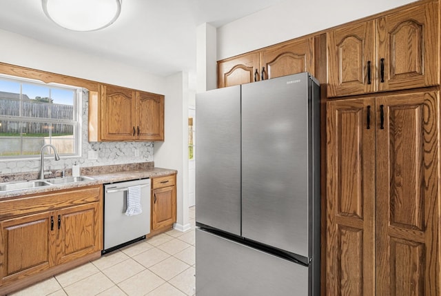 174 Hickory Ln, Jacksboro, TN 37757 - kitchen featuring light tile patterned floors, decorative backsplash, a sink, stainless steel appliances, and brown cabinetry