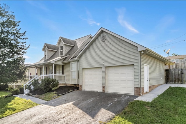 174 Hickory Ln, Jacksboro, TN 37757 - new england style home with a porch, fence, a garage, driveway, and roof with shingles