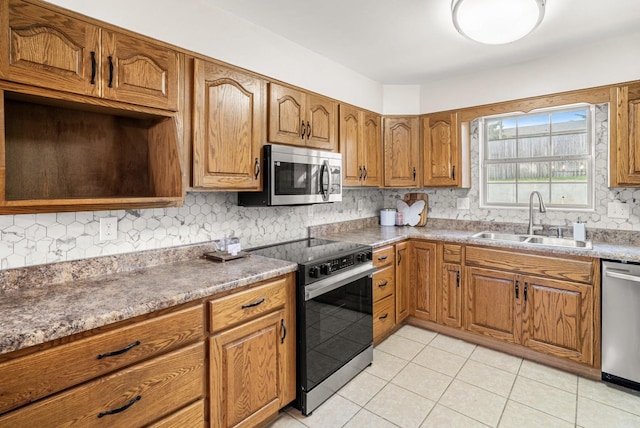 174 Hickory Ln, Jacksboro, TN 37757 - kitchen featuring light tile patterned floors, stainless steel appliances, brown cabinets, backsplash, and a sink