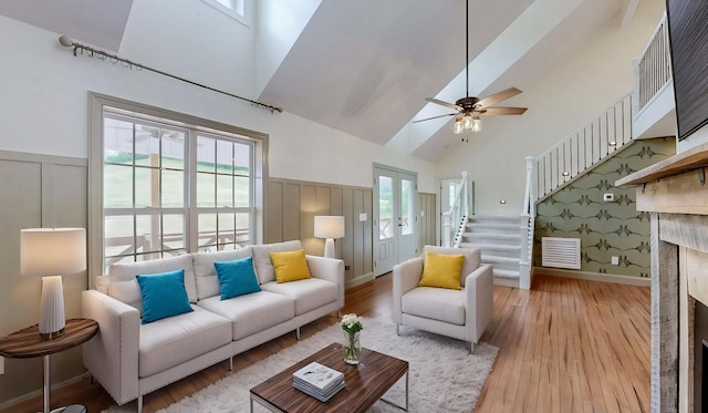 1344 French Brantley Rd, Wartrace, TN 37183 - living room with high vaulted ceiling, a decorative wall, wainscoting, stairs, and light wood-style floors