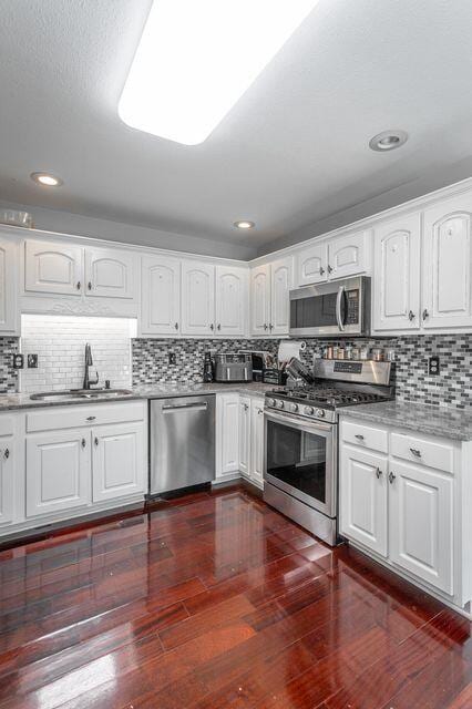 8424 Shadetree Ln, Ooltewah, TN 37363 - kitchen with appliances with stainless steel finishes, a sink, dark wood-type flooring, white cabinets, and recessed lighting