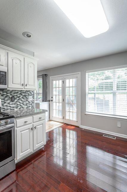 8424 Shadetree Ln, Ooltewah, TN 37363 - kitchen with stainless steel stove, dark wood-type flooring, white cabinets, baseboards, and a textured ceiling