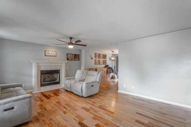 8424 Shadetree Ln, Ooltewah, TN 37363 - living area with light wood-type flooring, a fireplace, a ceiling fan, and baseboards