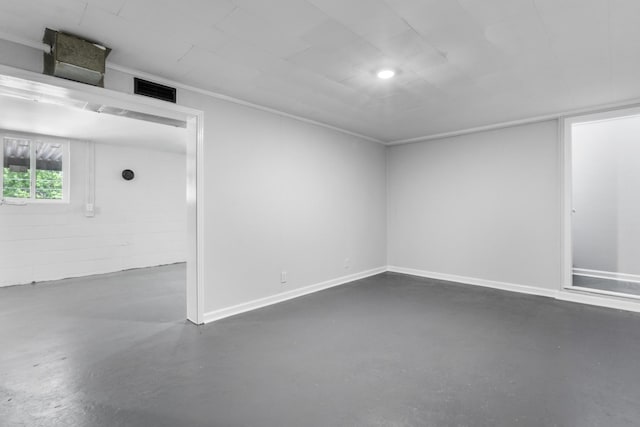 unfurnished room featuring baseboards, visible vents, ornamental molding, and finished concrete flooring