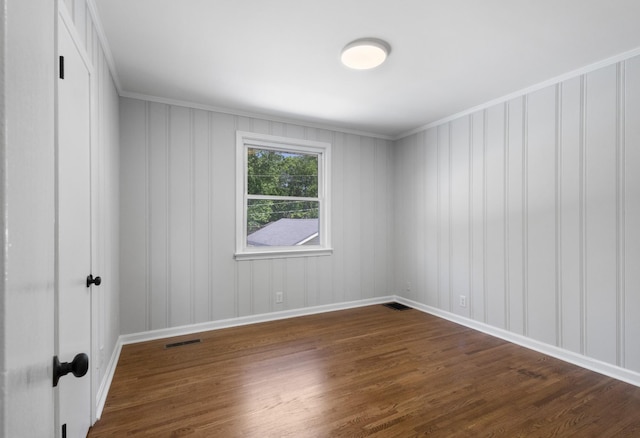 unfurnished room featuring crown molding, baseboards, dark wood-style floors, and visible vents