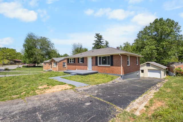 single story home with brick siding, an outbuilding, a front lawn, and a garage