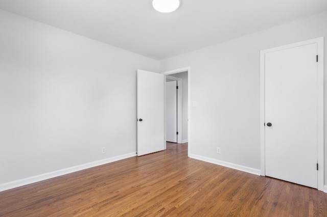 empty room with baseboards and wood finished floors