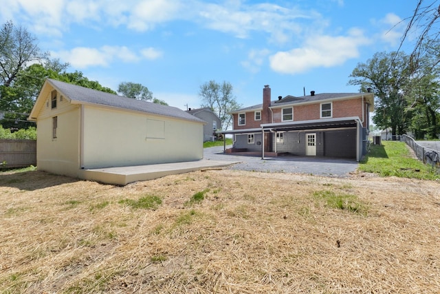 back of property with a patio, a chimney, brick siding, and fence