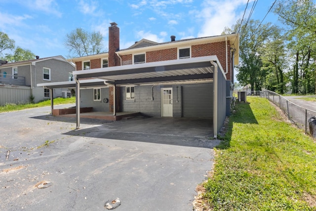 view of property featuring brick siding, fence, a chimney, and a front yard