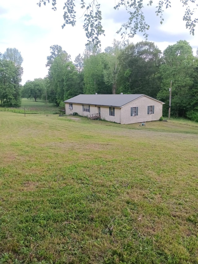 single story home with a wooded view and a front yard