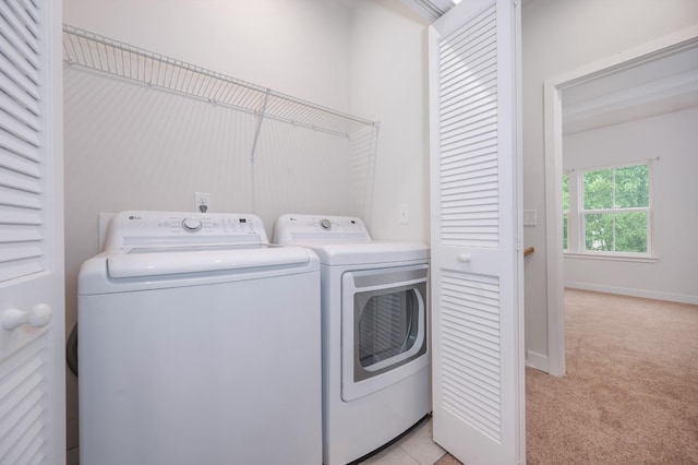 laundry area with washer and dryer, baseboards, laundry area, and light carpet