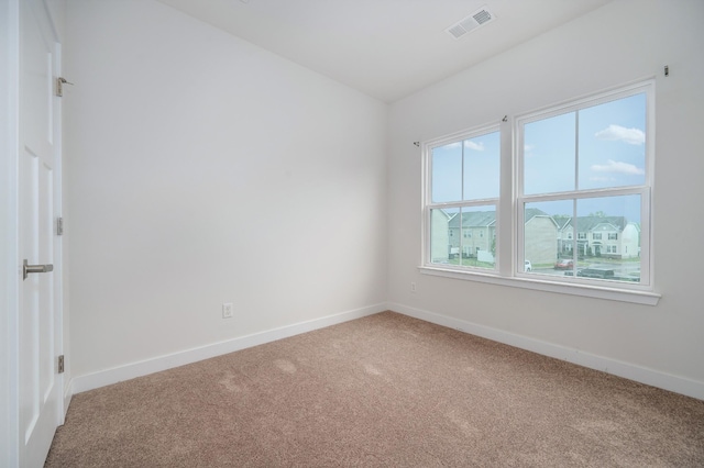 carpeted empty room with visible vents and baseboards