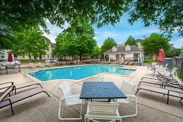 pool with a patio area and fence