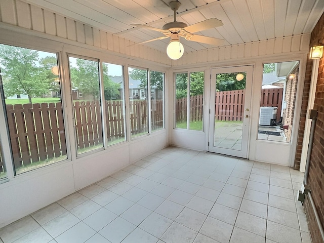 unfurnished sunroom featuring a ceiling fan