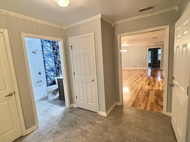 corridor featuring visible vents, ornamental molding, and baseboards