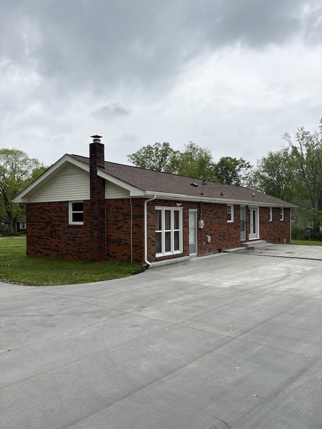 1400 Dogwood Ln, Lafayette, TN 37083 - rear view of house featuring a chimney, entry steps, brick siding, and driveway
