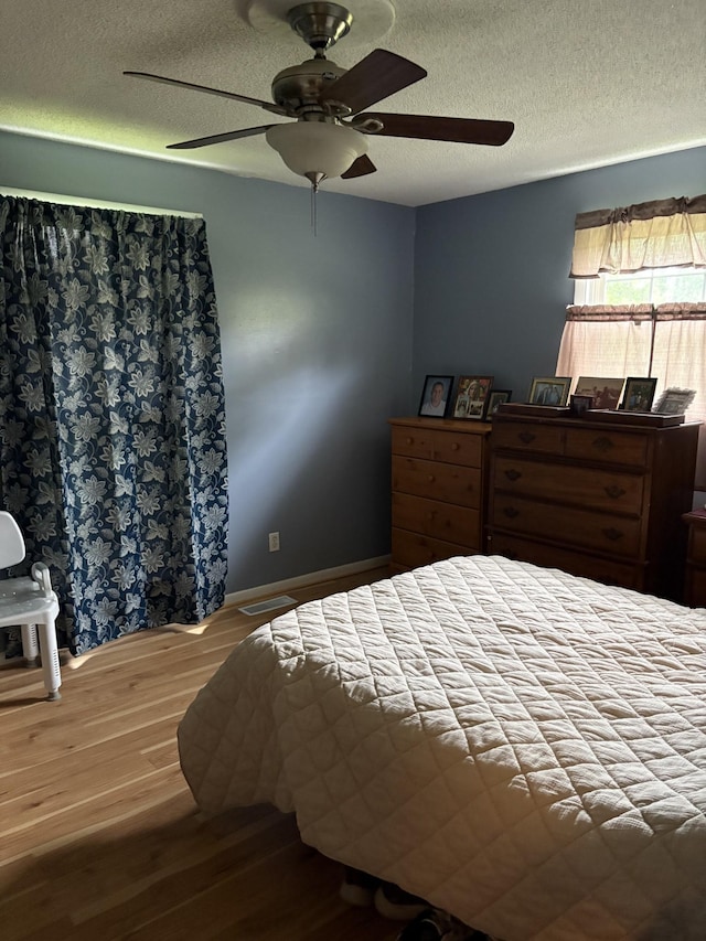1400 Dogwood Ln, Lafayette, TN 37083 - bedroom with a textured ceiling, visible vents, wood finished floors, and a ceiling fan