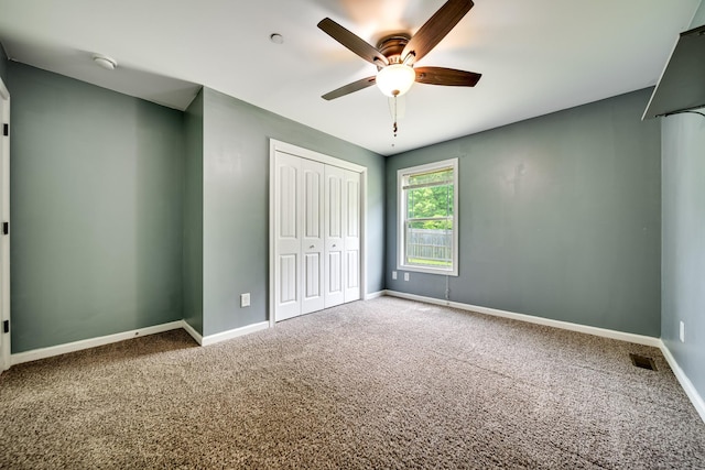 unfurnished bedroom featuring carpet flooring, baseboards, visible vents, and a closet