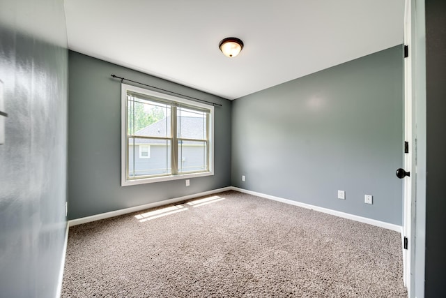 spare room featuring baseboards and carpet flooring