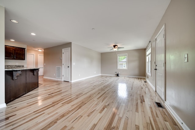 unfurnished living room featuring ceiling fan, light wood-style floors, recessed lighting, baseboards, and visible vents