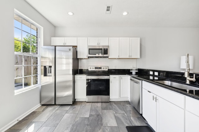605 Longfellow Ln, Smyrna, TN 37167 - kitchen with tasteful backsplash, appliances with stainless steel finishes, a sink, white cabinetry, and visible vents