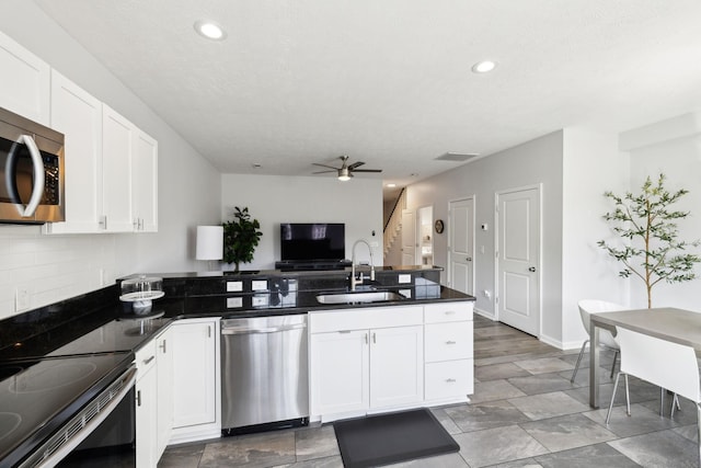 605 Longfellow Ln, Smyrna, TN 37167 - kitchen with appliances with stainless steel finishes, white cabinetry, a peninsula, and a sink