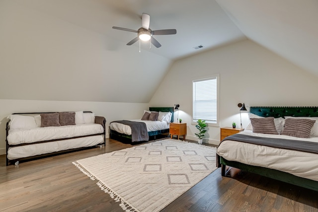 bedroom with wood finished floors, visible vents, a ceiling fan, and vaulted ceiling