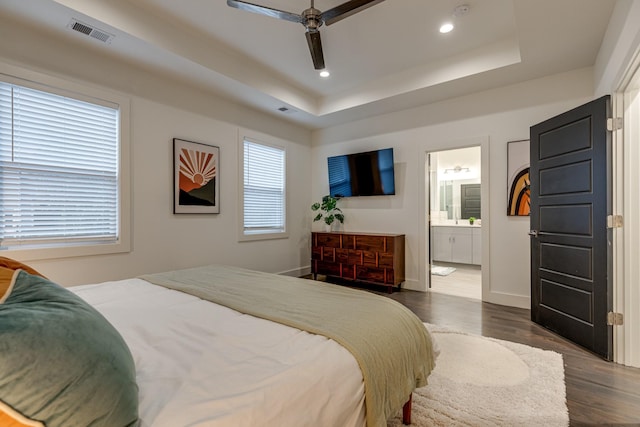 bedroom featuring recessed lighting, dark wood-style flooring, a raised ceiling, visible vents, and baseboards
