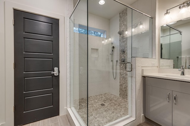 full bathroom with a stall shower, wood finished floors, and vanity