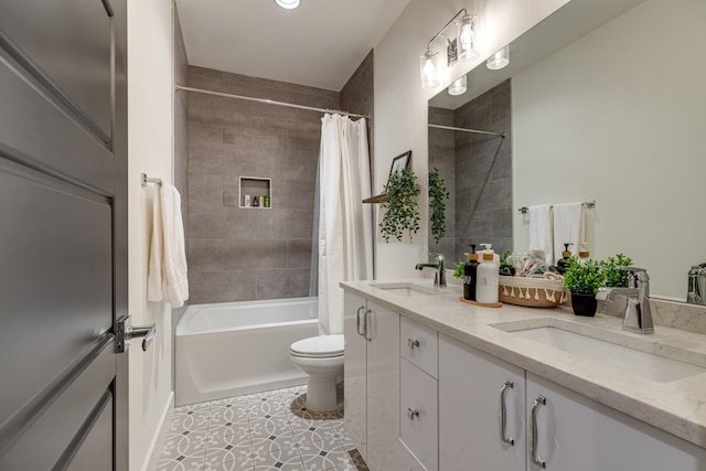 bathroom featuring double vanity, shower / bath combo with shower curtain, toilet, and a sink