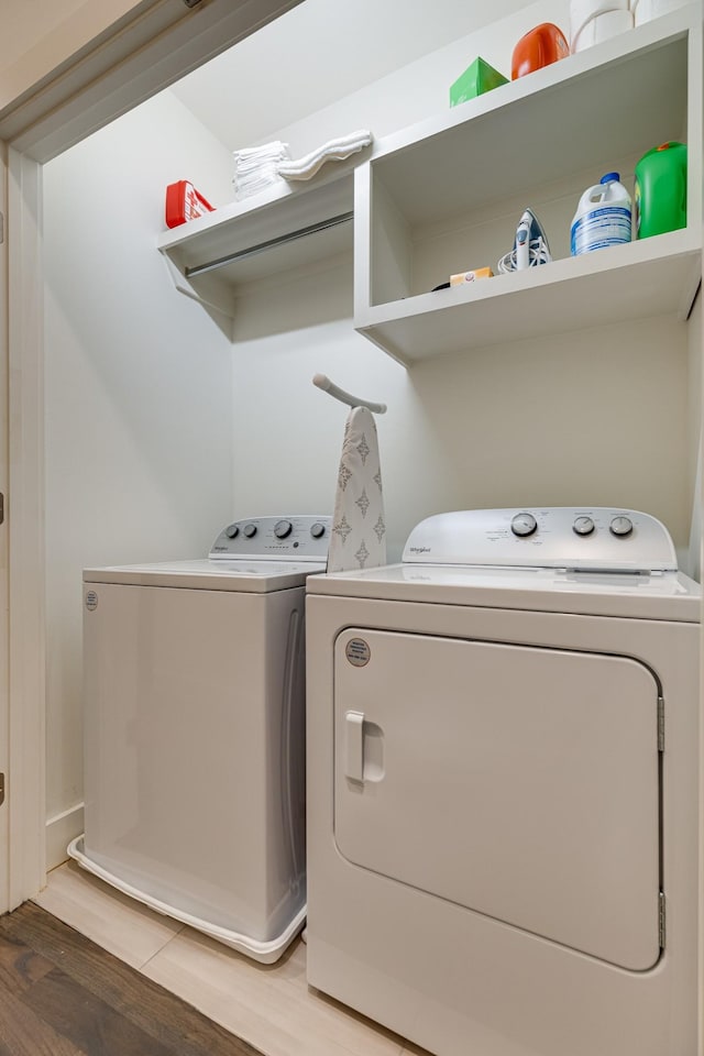 laundry room featuring light wood-type flooring, laundry area, and washing machine and dryer