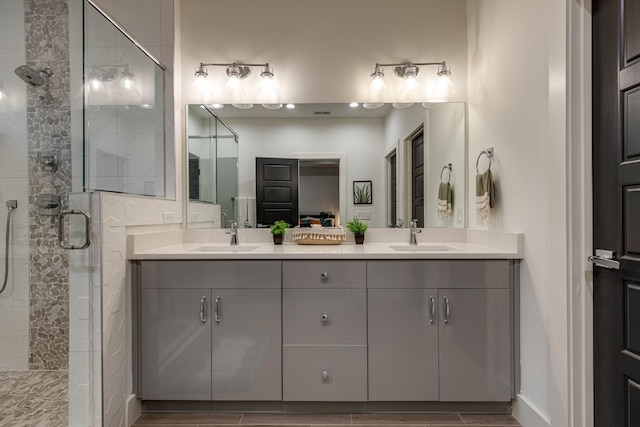 full bathroom featuring double vanity, wood finished floors, a stall shower, and a sink