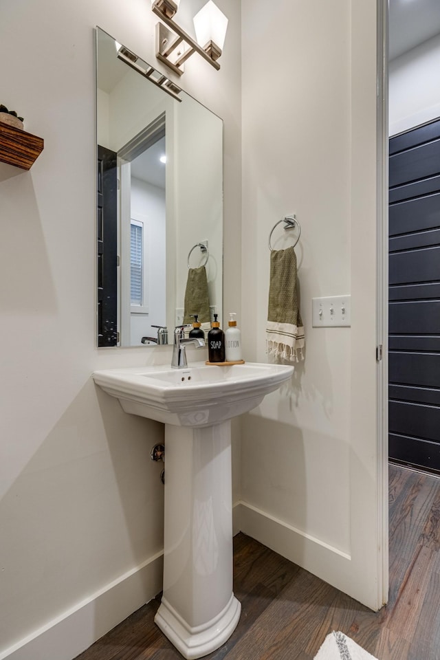 bathroom with baseboards and wood finished floors