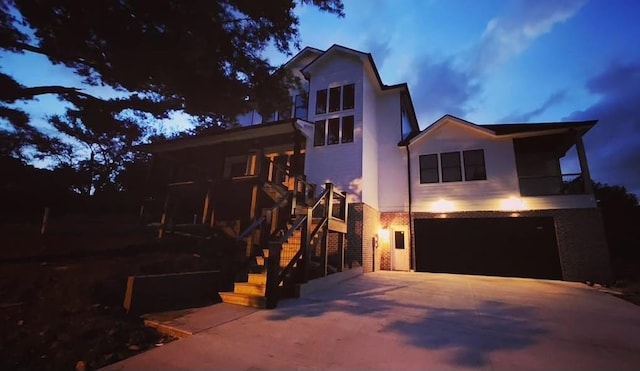 contemporary house featuring a garage, stucco siding, concrete driveway, and stairway