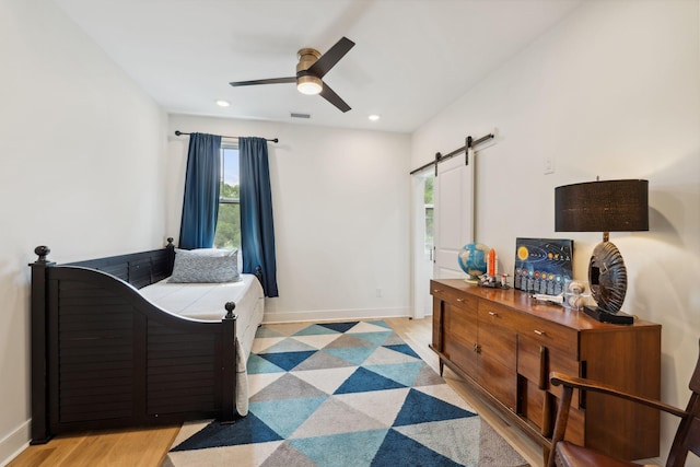 bedroom with recessed lighting, baseboards, visible vents, and a barn door