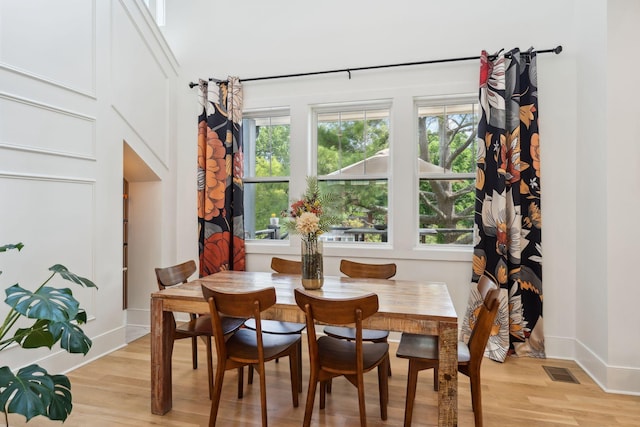 dining space with visible vents, light wood-style flooring, and baseboards