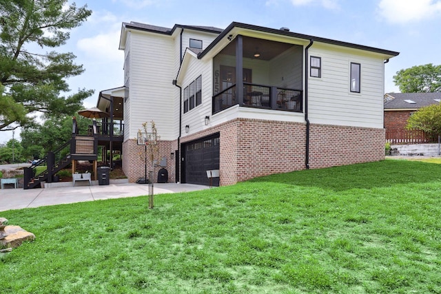 back of property with brick siding, an attached garage, a yard, and stairway