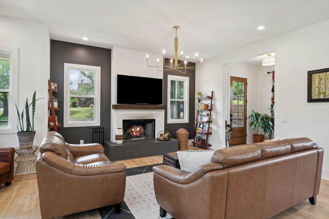 living area featuring recessed lighting, an inviting chandelier, plenty of natural light, and light wood-style flooring