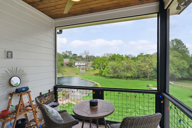 balcony featuring a water view and a ceiling fan