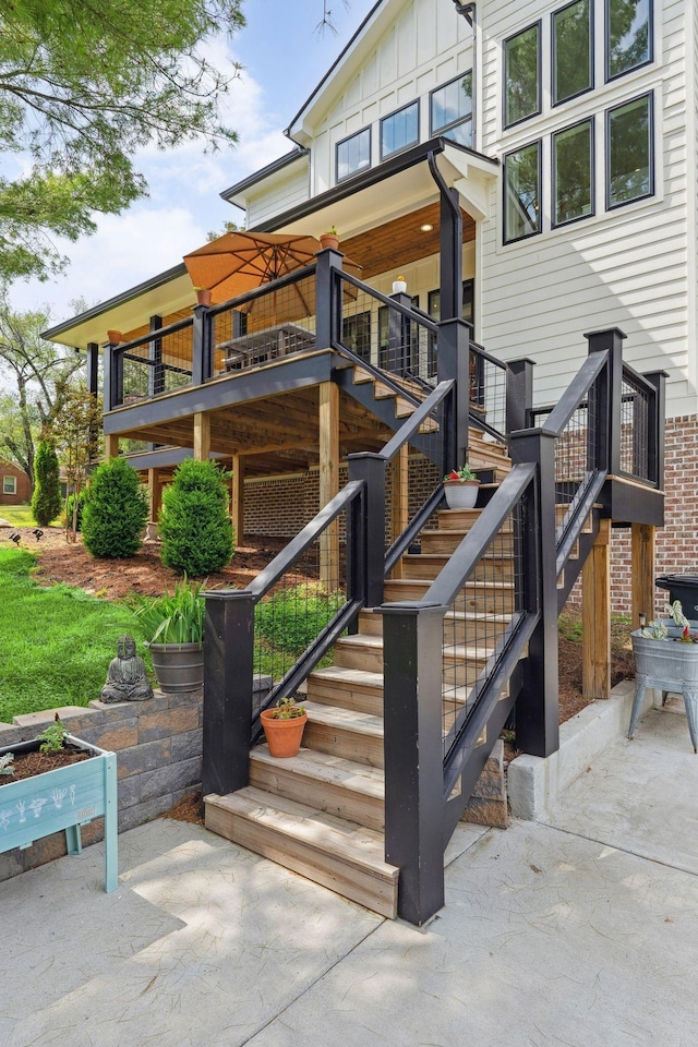 exterior space with board and batten siding and a patio area