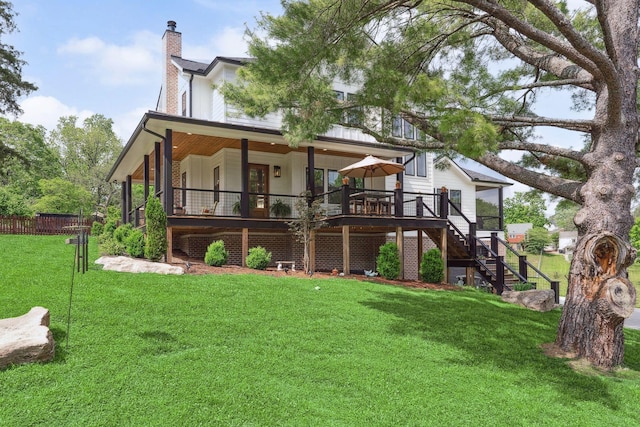 rear view of house with fence, stairs, a wooden deck, a chimney, and a yard