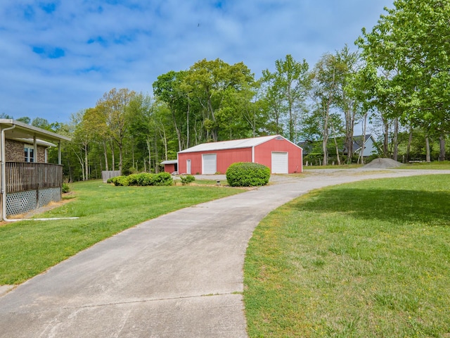 exterior space featuring a detached garage, an outbuilding, driveway, and a lawn