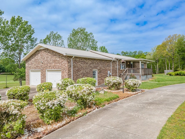 view of front facade with brick siding, a front yard, concrete driveway, and an attached garage