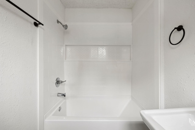 full bath with  shower combination and a textured wall