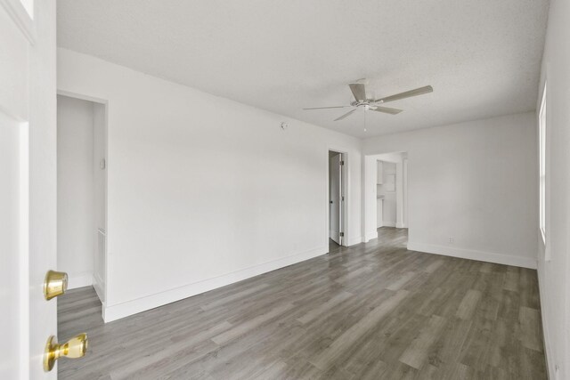 unfurnished room with baseboards, wood finished floors, and a ceiling fan