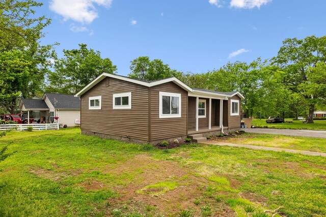 view of home's exterior featuring covered porch, crawl space, fence, and a lawn