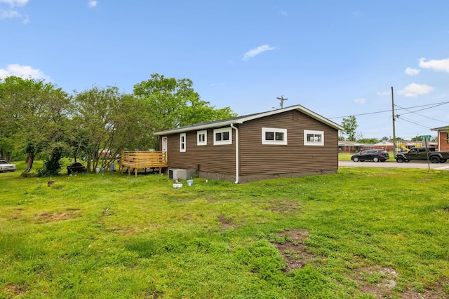 view of side of property with a deck, crawl space, and a lawn